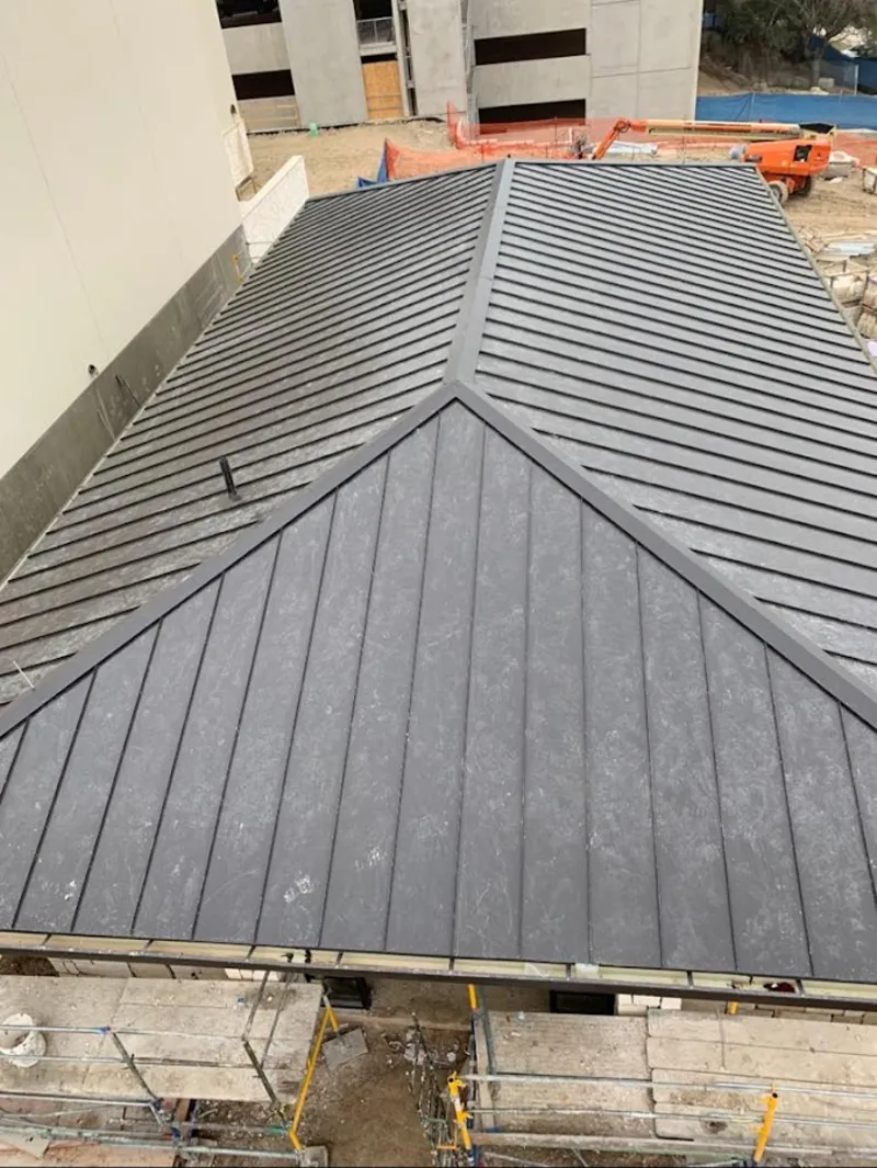 Commercial metal roof construction with crane equipment in Tea